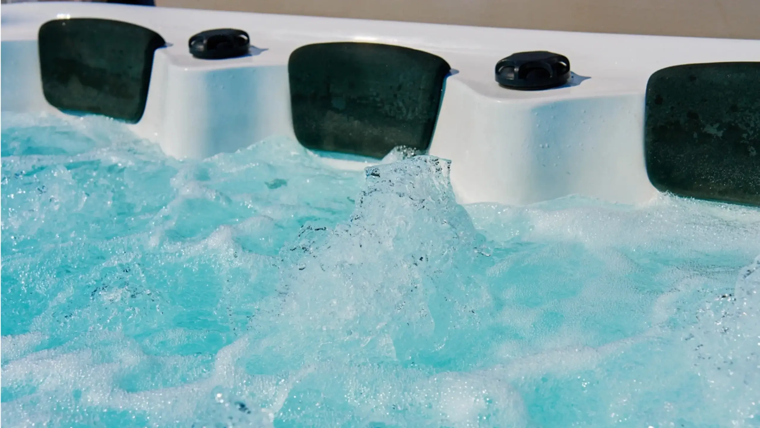 Jak dbać o wodę w jacuzzi — grafika przedstawia zbliżenie na wirującą wodę w jacuzzi z poduszkami do siedzenia.