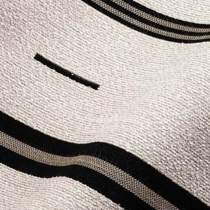 wzór tkaniny geometryczny, etniczny (plemienny), składający się z bloków pasów, w tym pasków ze splotem w jodełkę (chevron) oraz drobnych, czarnych kresek na jasnym tle