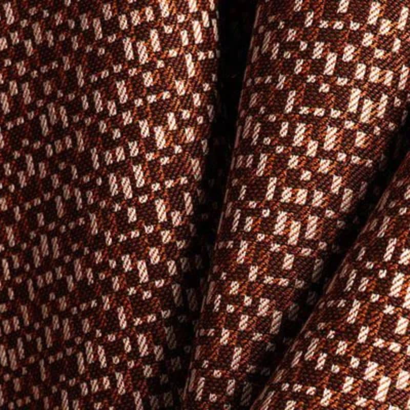 Carat_Grenat_CARA_J637(2) teksturowana, dwukolorowa tkanina dekoracyjna (outdoorowa) z geometrycznym wzorem kraty/pionowych kresek, utrzymana w ciepłej kolorystyce brązu/granatu i rdzawego pomarańczu, z jasnymi, akcentującymi elementami